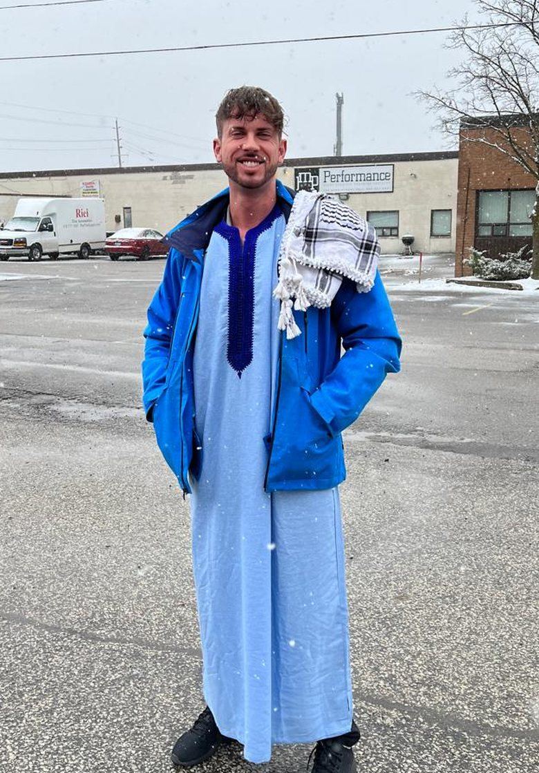 Jordan Moyer (Saifullah) in a thobe and keffiyeh, founder of Amanah Coach